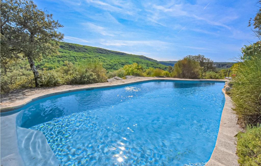 a swimming pool in the middle of a yard with trees and hills at Awesome Home In Bonnieux With Sauna in Bonnieux