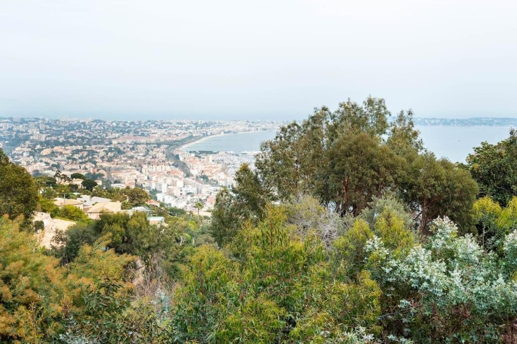 a view of a city from a hill with trees at VILLA LE MAS D&#39;AZUR BY ESTATESCANNES in Vallauris