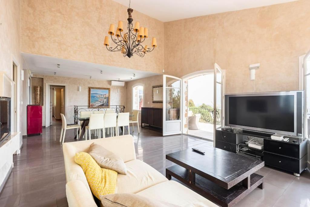 a living room with a couch and a tv at VILLA LE MAS D&#39;AZUR BY ESTATESCANNES in Vallauris