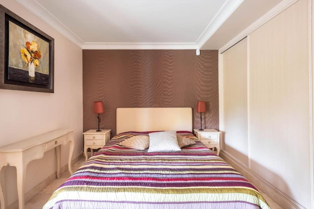 a bedroom with a large bed with two night stands at VILLA LE MAS D&#39;AZUR BY ESTATESCANNES in Vallauris