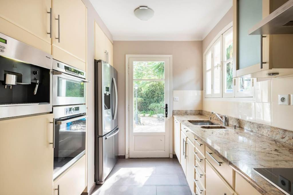 a kitchen with a sink and a refrigerator at VILLA LE MAS D&#39;AZUR BY ESTATESCANNES in Vallauris