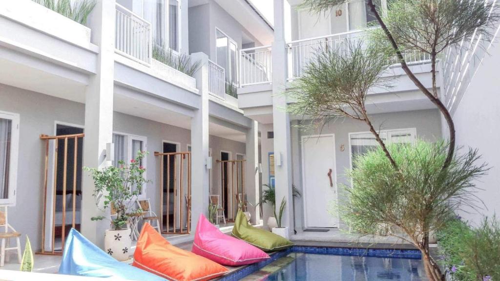 吉利特拉旺安的住宿－Mantra Gili，游泳池旁的一栋带色彩缤纷枕头的建筑