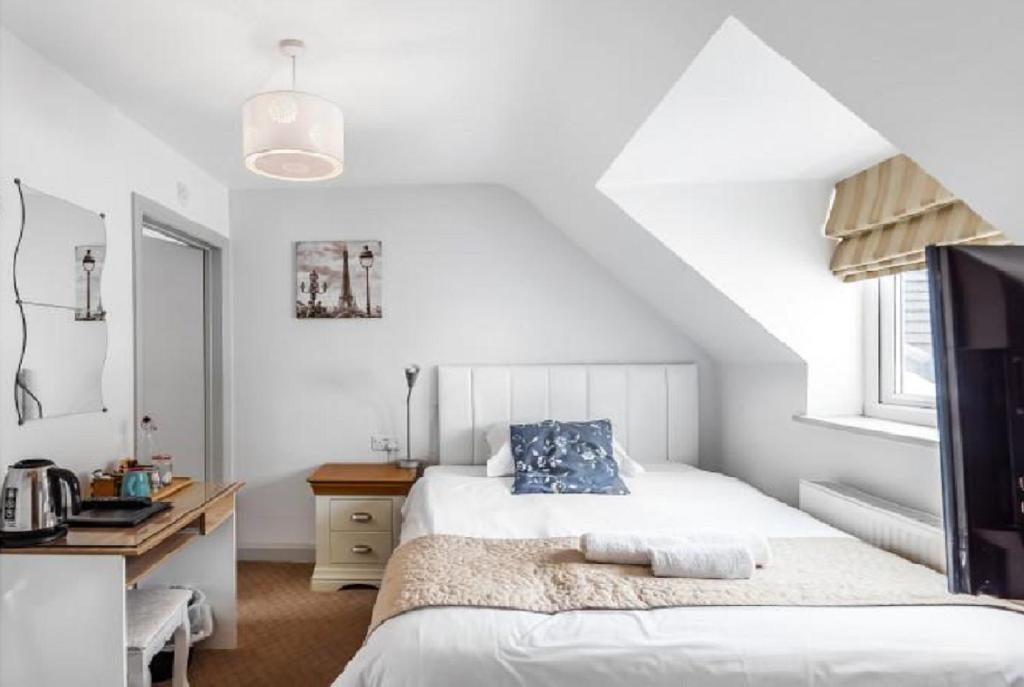 a bedroom with a bed and a desk and a bed at Oxford Guest House in Oxford