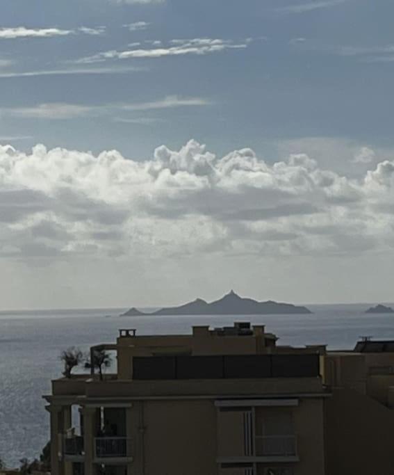 - un bâtiment avec vue sur l'océan et les montagnes dans l'établissement SUPERBE APPARTEMENT FACE AUX ILES SANGUINAIRES, à Ajaccio