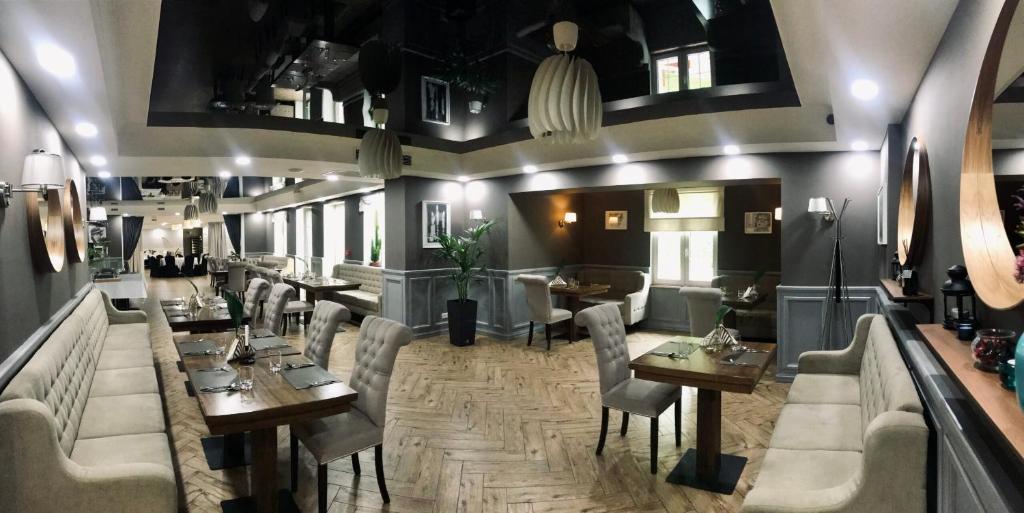 ein Restaurant mit Tischen und Stühlen in einem Zimmer in der Unterkunft Pod Platanem Gliwice in Gliwice