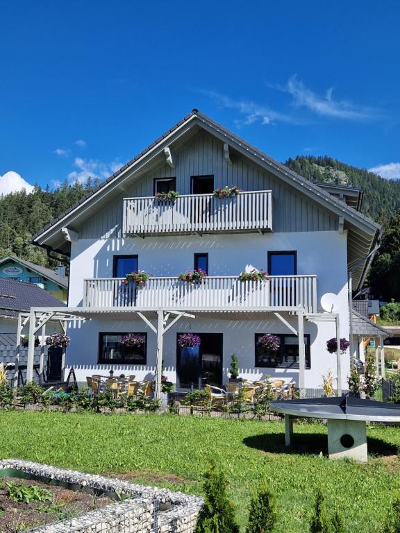 a white house with a balcony and a bench at Haus Karina in Bad Mitterndorf