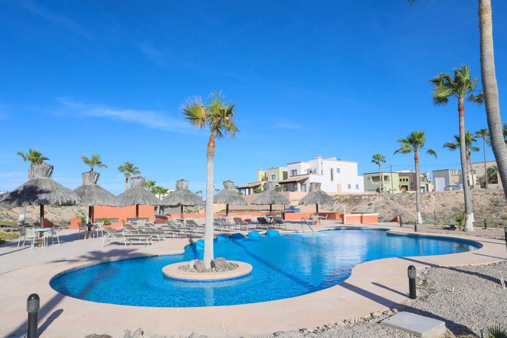 una piscina con sillas y palmeras en un complejo en Brand New Home - The Village in Las Conchas #38, en Las Conchas