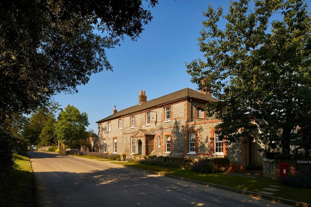 uma velha casa de tijolos com uma estrada em frente em The Goodwood Hotel em Chichester