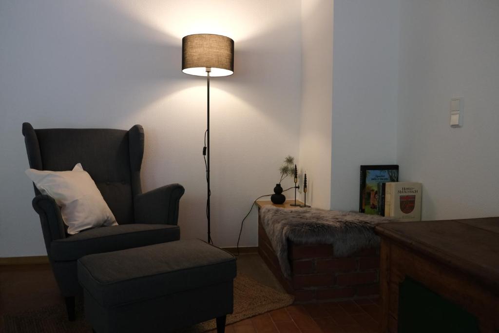 a living room with a chair and a lamp at Ferienwohnung Casa Bella 