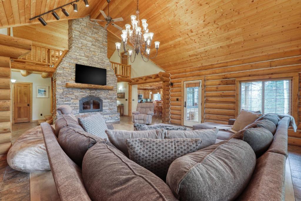 a living room with a large couch and a fireplace at Woodland Wonder in Brian Head