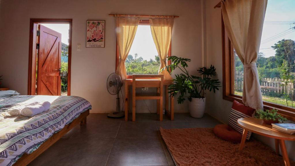 um quarto com uma cama, uma secretária e uma janela em Pinky Moon House Măng Đen em Kon Von Kla