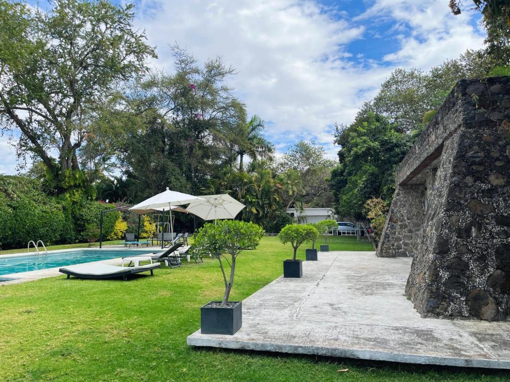 un jardín con piscina y árboles y un edificio en Increíble casa familiar c/ alberca climatizada!, en Yautepec