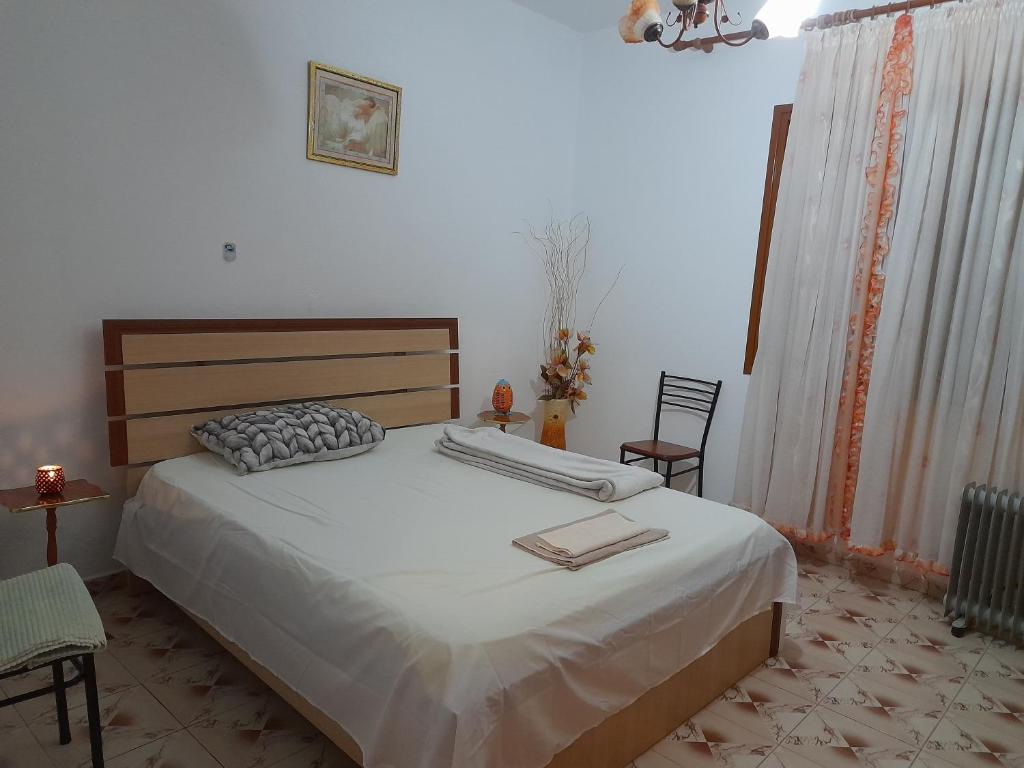 a bedroom with a large bed and two chairs at Cortina House Berat in Kuçovë