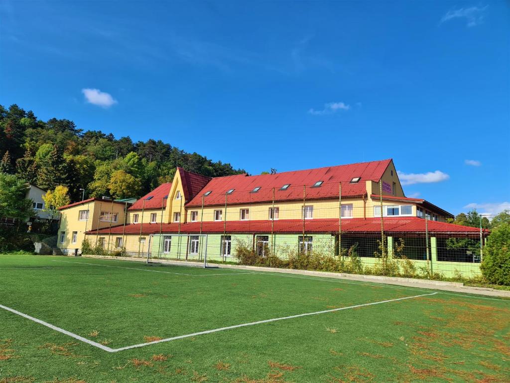 un gran edificio con una pista de tenis enfrente en Penzion Olympia en Banská Bystrica