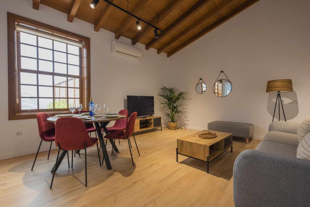 een woonkamer met een tafel en stoelen en een bank bij Los Adelantados La Hornacina Live Canarias in La Laguna