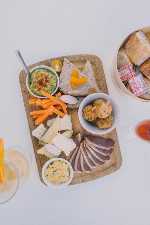 a cutting board with different types of food on it at Hotel Du Bac in Combrit
