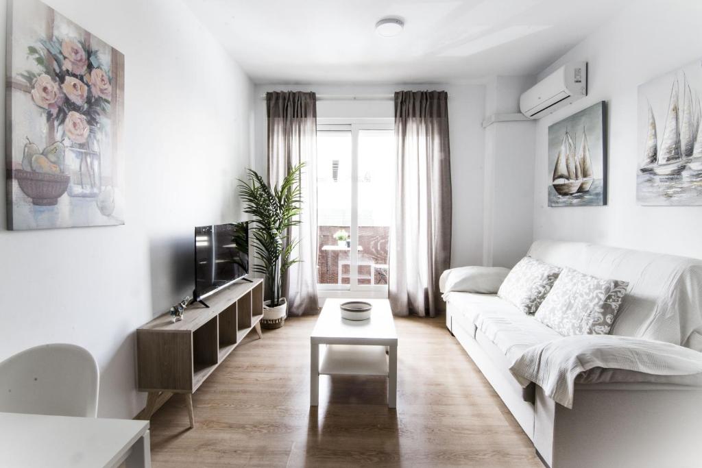 a white living room with a white couch and a table at Apartamento San Juan in El Puerto de Santa María