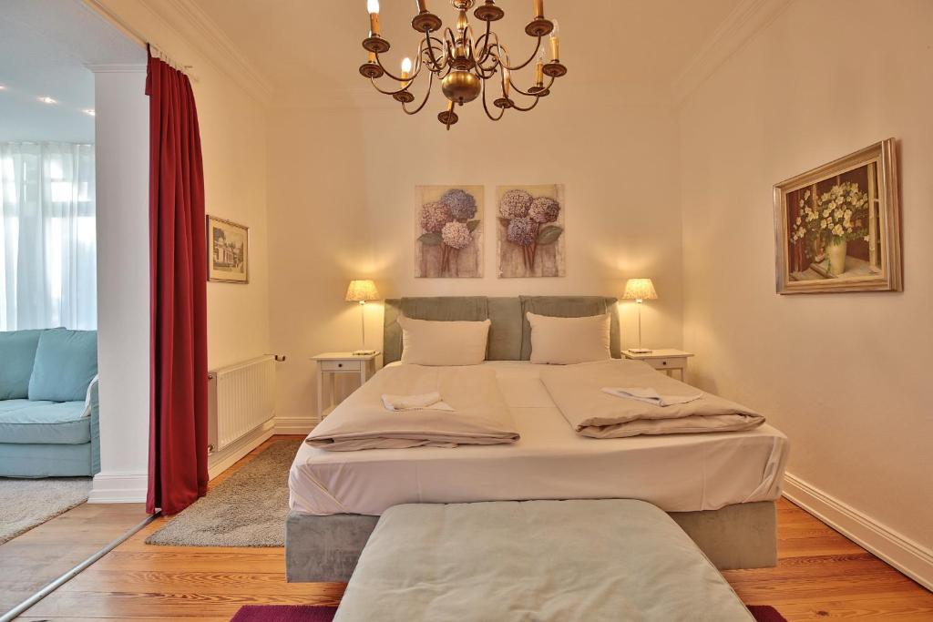 een slaapkamer met een groot bed en een kroonluchter bij Villa Schöneck Villa Schöneck Appartement 2 in Scharbeutz