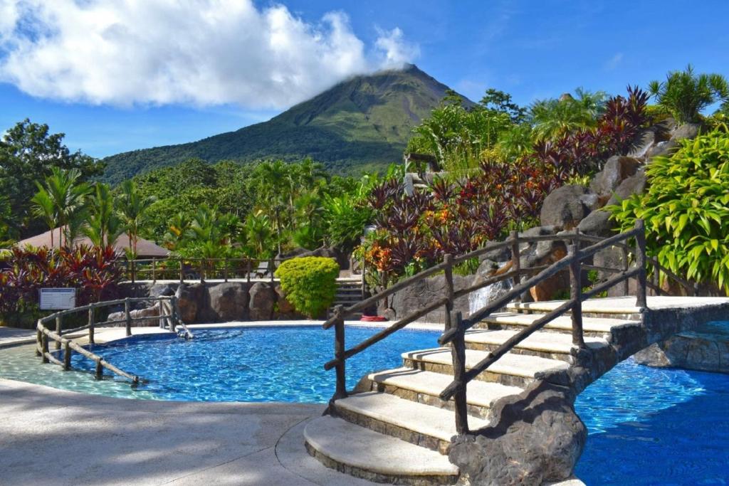 una piscina resort con una montaña en el fondo en Los Lagos Spa & Thermal Resort Experience, en Fortuna
