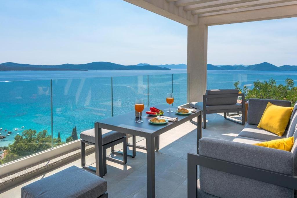 un patio con mesa y sillas y vistas al océano en Villa Vanna, en Slano