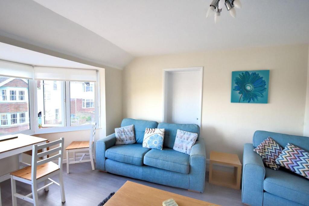 uma sala de estar com um sofá azul e uma mesa em Little Gem em Lyme Regis