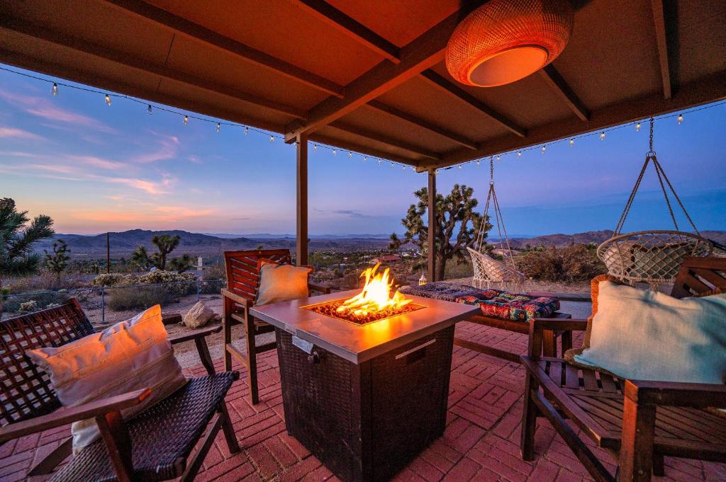 a fire pit on a patio with a view of the mountains at The Full Moon, Joshua Tree: Hot Tub, Sauna, Views in Joshua Tree