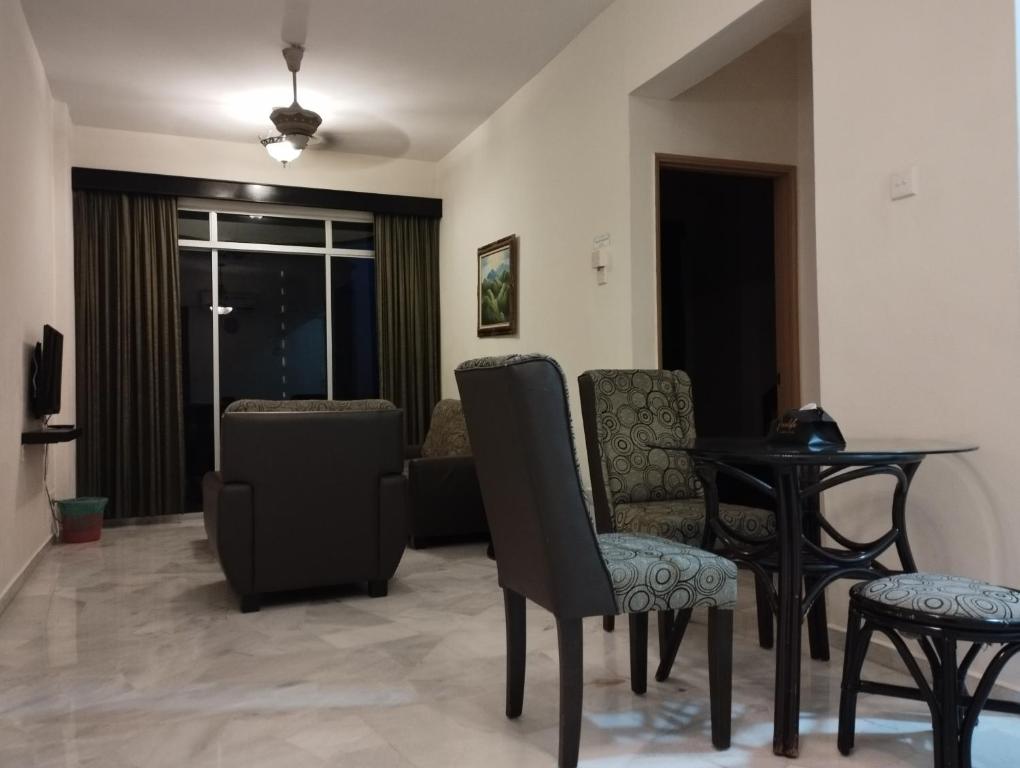 GloRy BeAch ResOrt private apartment في بورت ديكسون: غرفة معيشة مع كراسي وطاولة