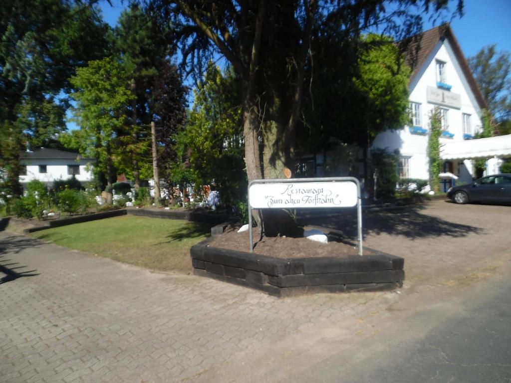 un cartel en un parque al lado de una casa en Hotel zum alten Torfkahn, en Osterholz-Scharmbeck