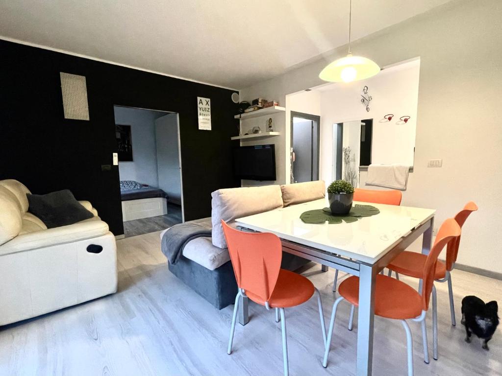 uma sala de estar com uma mesa e cadeiras e um sofá em Diamond House em Mattarello