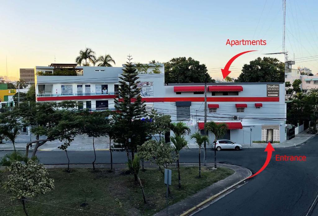 un bâtiment blanc avec une flèche rouge pointant vers un appartement dans l'établissement Studios Don Bosco, à Saint-Domingue