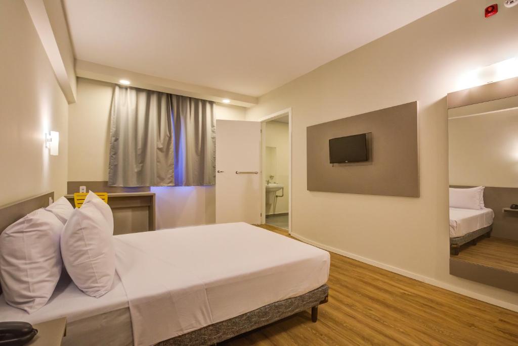 a hotel room with a bed and a tv at Transamerica Fit Rio Verde in Rio Verde
