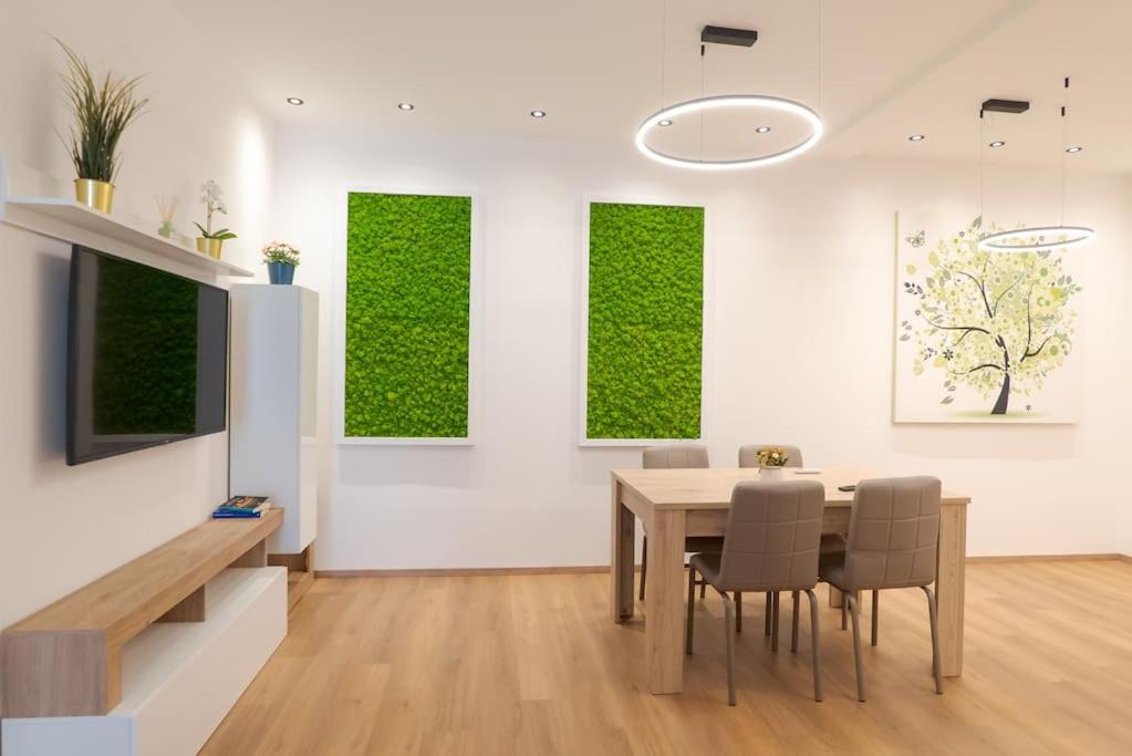 ein Esszimmer mit einem Tisch und einer grünen Wand in der Unterkunft Appartamento incantevole fronte mare in Villa Rosa