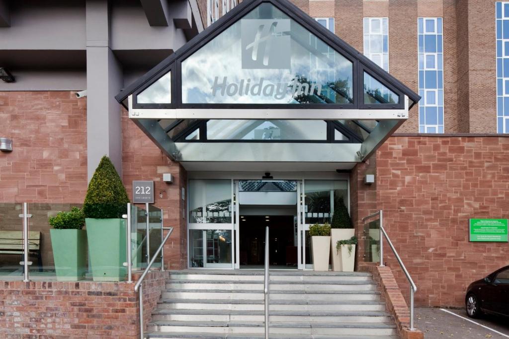 un edificio con un cartel en la parte delantera en Holiday Inn Kenilworth - Warwick, an IHG Hotel, en Kenilworth