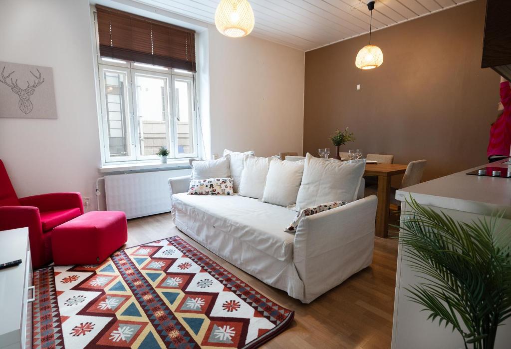 sala de estar con sofá blanco y silla roja en 2ndhomes Central 1BR Apartment with Great Location by Kaisaniemi Park, en Helsinki