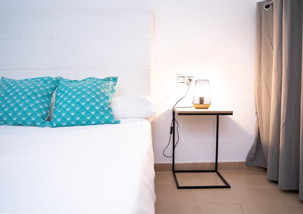 1 cama con almohada azul y mesa auxiliar en Apartamento Avilés, en Ronda