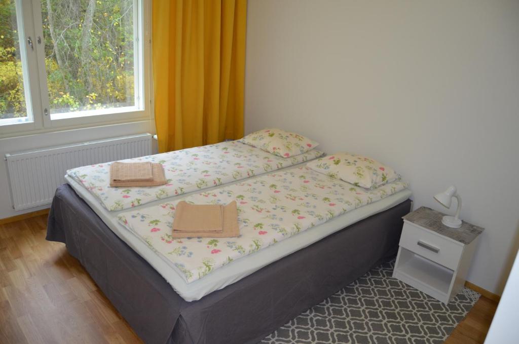 a bed in a bedroom with two boxes on it at Lahti Hietaneilikka Apartments in Lahti