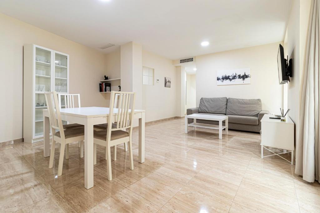 sala de estar con mesa, sillas y sofá en Allo Apartments Consistorio Centro 2 Habitaciones, en Jerez de la Frontera