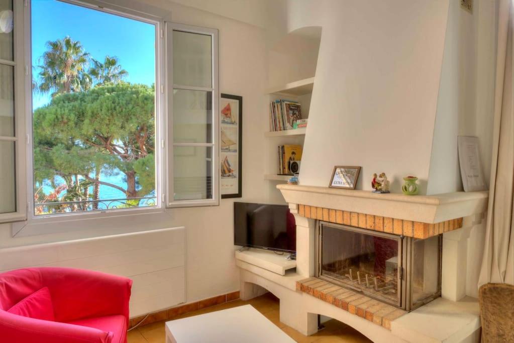 a living room with a fireplace and a window at Appartement Villa Tamaris, vue mer in La Seyne-sur-Mer