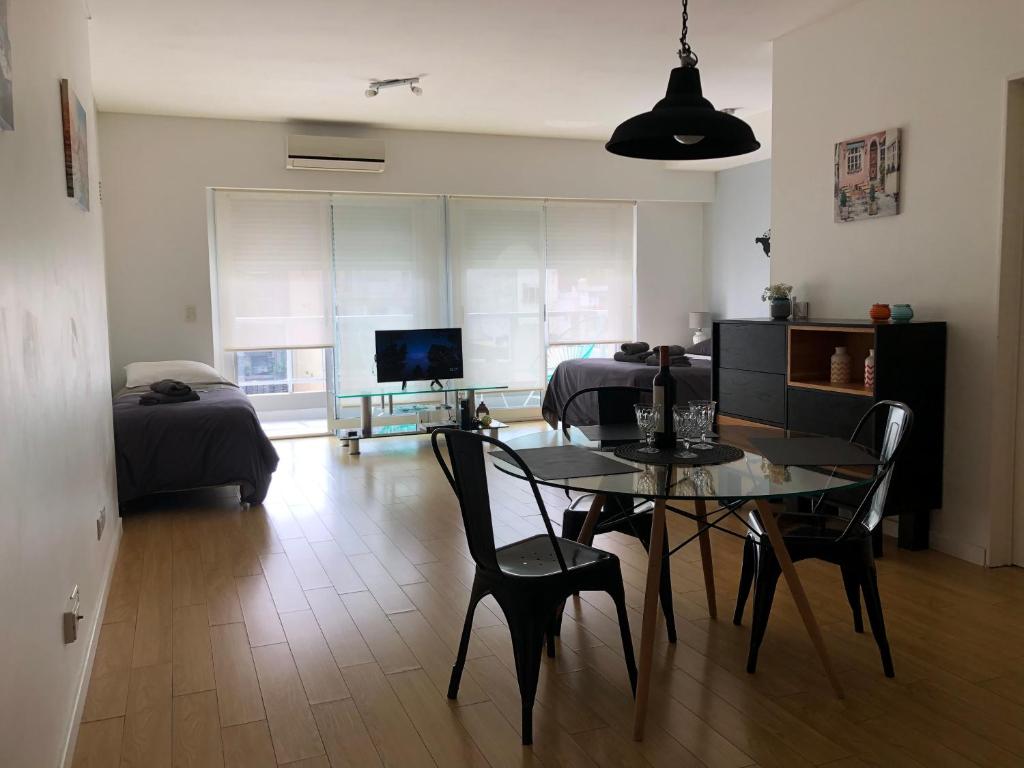 ein Wohnzimmer mit einem Tisch und Stühlen sowie ein Schlafzimmer in der Unterkunft Cozy Studio in Palermo Soho with security 24 hs in Buenos Aires