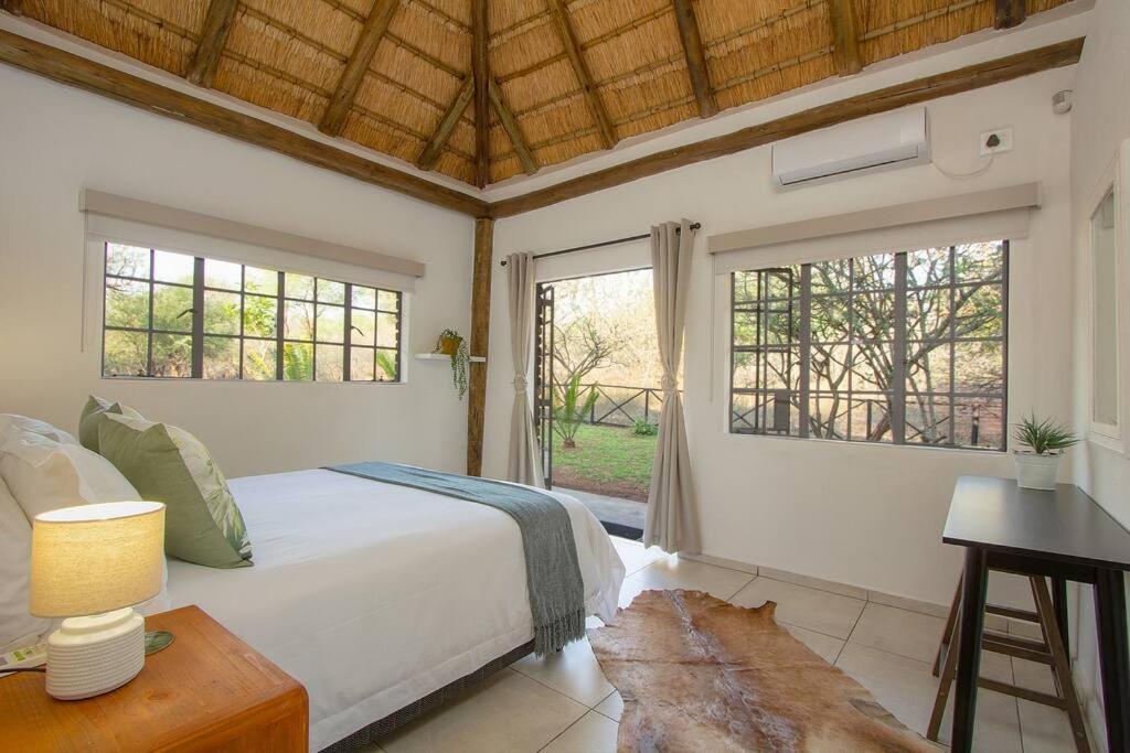 マールロス・パークにあるEye of Kruger - Spacious holiday home with splash pool and bomaのベッドと机と窓のある寝室