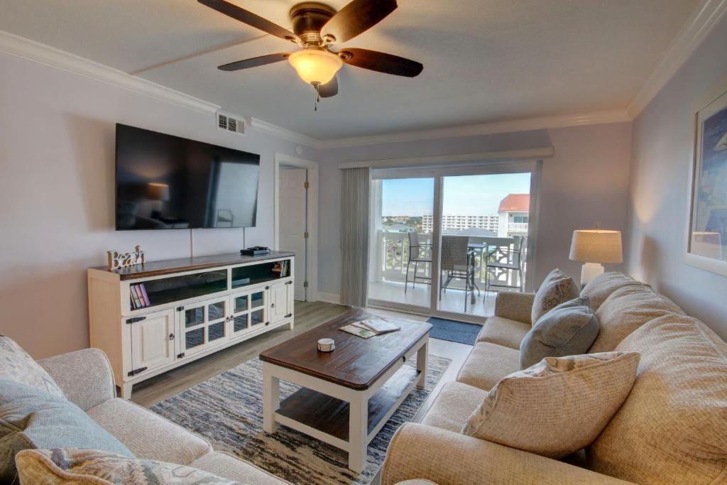 een woonkamer met een bank en een flatscreen-tv bij El Matador 461 - Beautiful views of the pool and Gulf of Mexico in Fort Walton Beach
