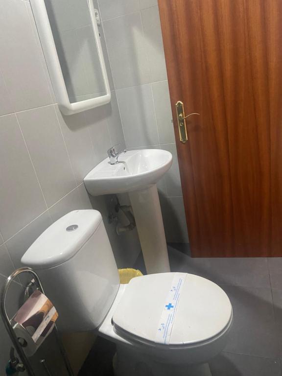 ein Badezimmer mit einem weißen WC und einem Waschbecken in der Unterkunft Pensión LF No Fumadores - Sin Ascensor in Saragossa