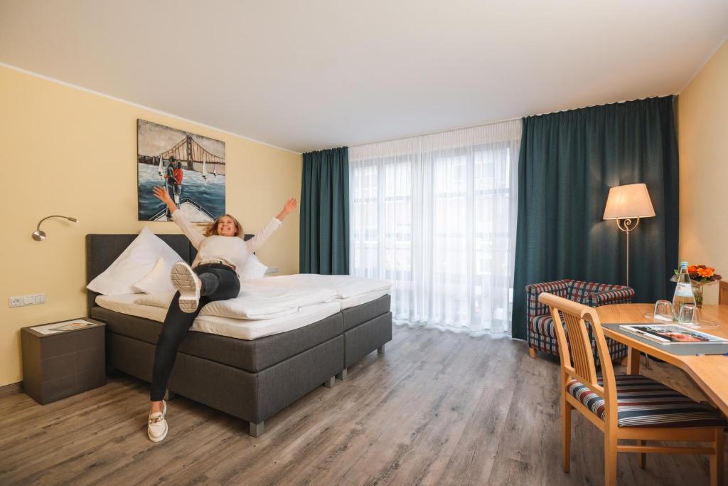 una mujer acostada en una cama en una habitación de hotel en Hotel am Park en Hückelhoven