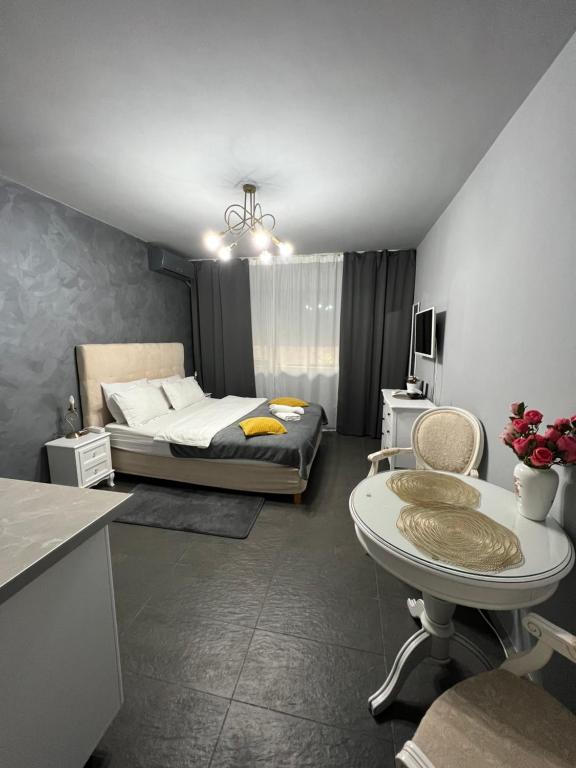 a bedroom with a bed and a table in it at Kenzia Prive in Bucharest