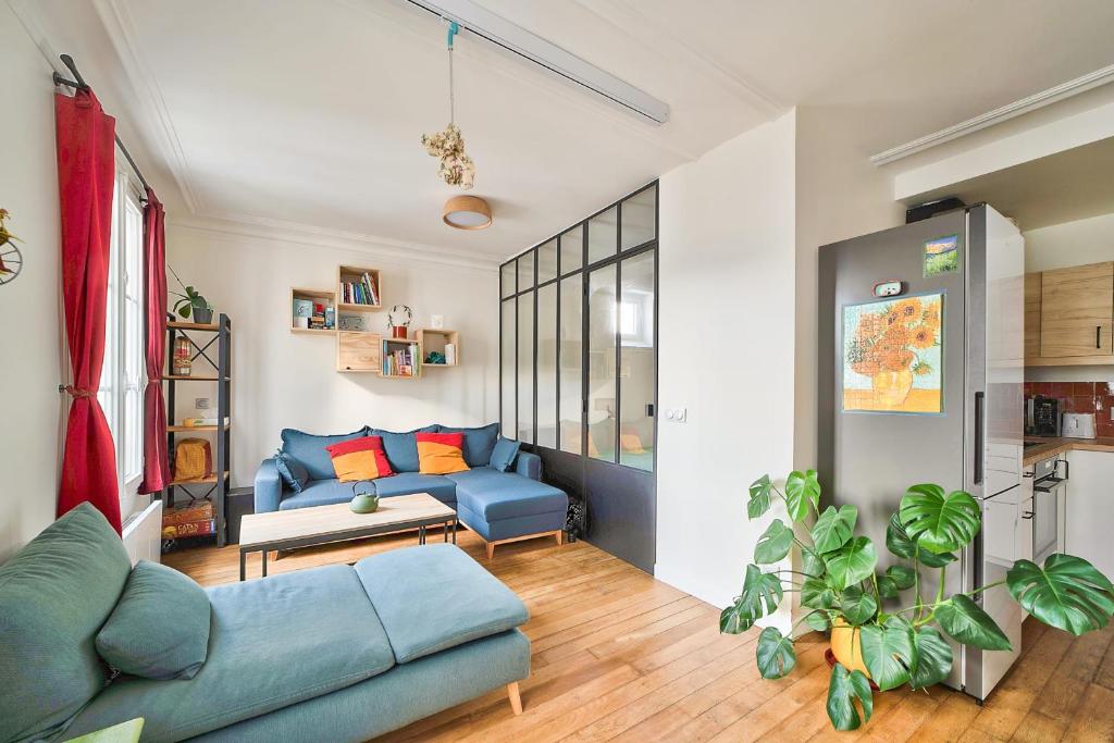 uma sala de estar com um sofá azul e uma mesa em Comfortable apartment in the heart of Paris - Welkeys em Paris