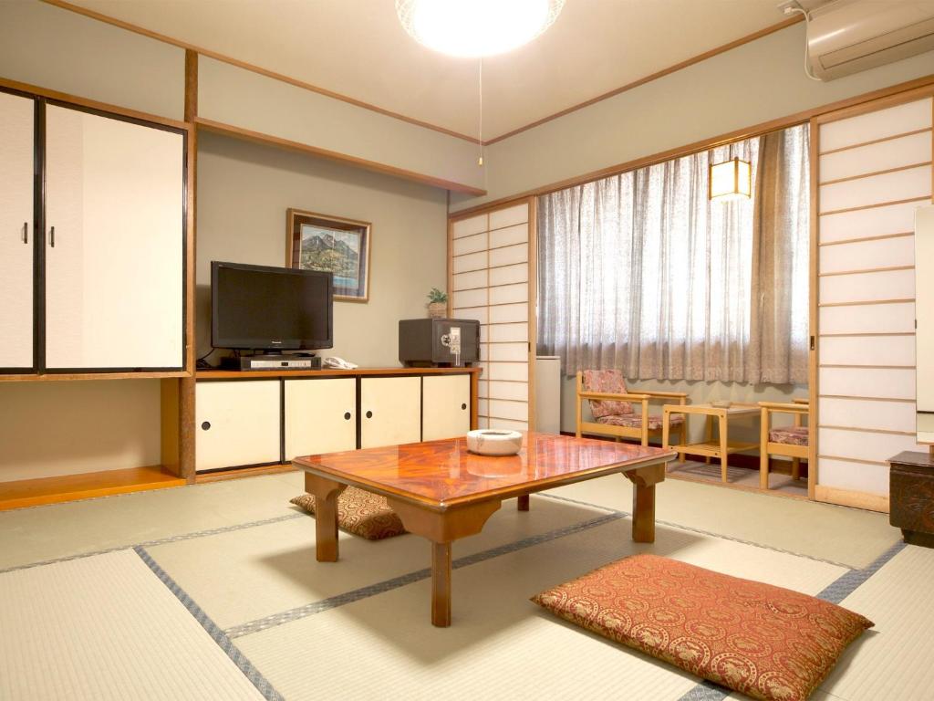 a living room with a table and a television at Kanko Hotel Yumotokan - Vacation STAY 60199v in Gero