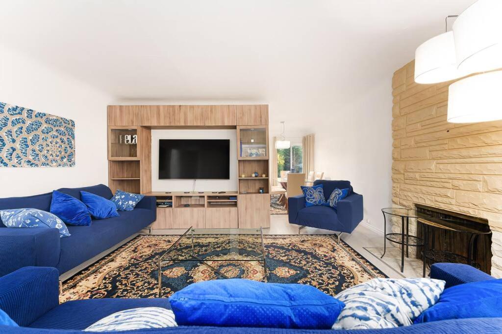 a living room with blue couches and a tv at Amazing House In The Heart Of Vancouver DT/YVR/UBC in Vancouver