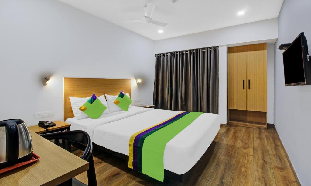 a hotel room with a large bed and a desk at Treebo Trend Town Plaza, Pune Station in Pune