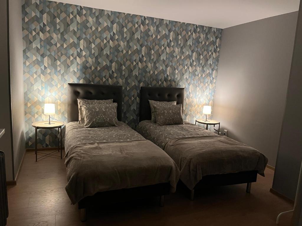 duas camas num quarto com duas lâmpadas nas mesas em Aizkraukle Penthouse apartment em Aizkraukle