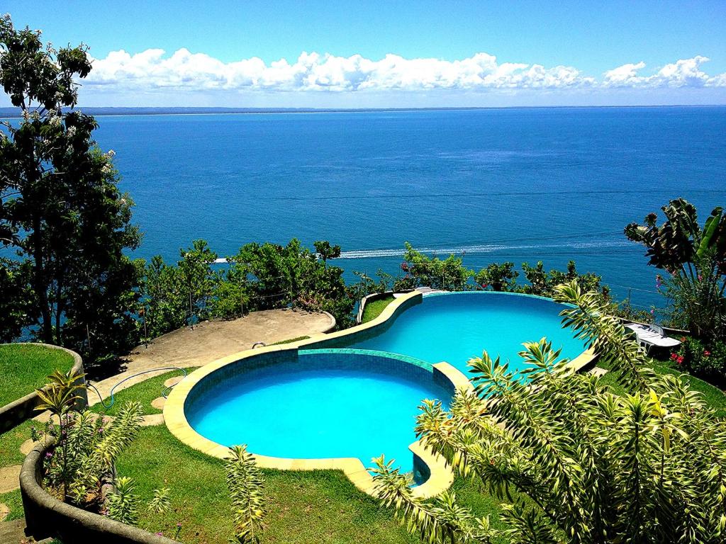 a swimming pool with the ocean in the background at Bangalô dos Sonhos in Morro de São Paulo